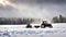 The tractor pulls a snowy car in the snow in winter landscape in