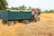 Tractor pulls up for loading to the combine with wheat