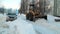 Tractor raking snow in the yard in Russia in winter