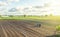 A tractor rides on a farm field. Farmer on a tractor with milling machine loosens, grinds and mixes soil. Farming and agriculture