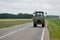 Tractor rides on the road rear view