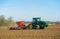 Tractor with seed drill sowing seeds in the Spring. Hertfordshire. UK