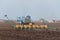 A tractor with a seeder sows wheat