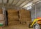 Tractor in a shed with haystacks