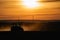 Tractor silhouette in the field on the orange-yellow sunset