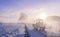 Tractor silhouette through fog, on snowy field