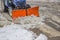 Tractor snowplow is cleaning the pedestrian crossing and sprinkling salt