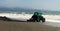 Tractor on Spanish beach, races to stem the tide.