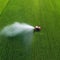 Tractor spray fertilizer on green field drone high angle agriculture background concept