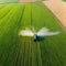 Tractor spray fertilizer on green field drone high angle agriculture background concept