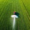 Tractor spray fertilizer on green field drone high angle agriculture background concept