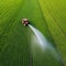 Tractor spray fertilizer on green field drone high angle agriculture background concept