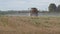 Tractor spray stubble field with herbicide chemicals in autumn