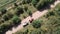 Tractor with sprayer on countryside road. Farm machinery driving on gravel trail road in field. Tractor with boom sprayer on sunny