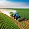 Tractor spraying pesticides fertilizer on soybean crops farm field in spring Smart Farming Technology and Sustainable