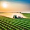 Tractor spraying pesticides fertilizer on soybean crops farm field in spring Smart Farming Technology and Sustainable