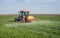 Tractor spraying wheat field