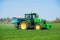 Tractor sprinkling fertiliser on wheat crop field. Hertfordshire. UK