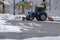 Tractor is sweeping snow in snowfall