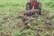 Tractor tilling the soil with vibrant green grass background