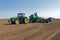 Tractor with trailed seeder on the field