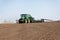 Tractor with trailed seeder on the field