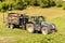 Tractor with a trailer carries firewood through the green field