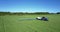 Tractor with trailer tank sprinkles soybean field with chemicals