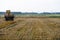 Tractor on trailer transports large round bales of hay. Transportation of hay to places for storage and drying of silage.