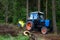 Tractor with trailer of wood choppers and branches, wood chipper