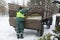 Tractor, trailer and the worker putting branches of used Christmas tree in the trailer. Collection point for recyc