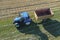 A tractor transports the ripe golden wheat to the grain field harvested by the combine. Agricultural work in summer. Drone