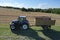 A tractor transports the ripe golden wheat to the grain field harvested by the combine. Agricultural work in summer. Drone