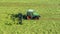 A tractor turns up the grass, aerial view.