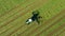 A tractor turns up the grass, aerial view.