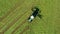 A tractor turns up the grass, aerial view.