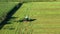 A tractor turns up the grass, aerial view.