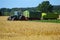 Tractor with two trailers at harvest on a wheat field