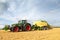 Tractor using a baler in a field. UK