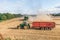 Tractor wagon and combine machine engaged in harvesting grain