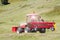 Tractor with windrower swather moving on a gravel road