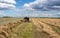 Tractor working with wheel rake in field