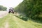 Tractors machines mowing lawn grass along road