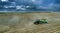 Tractors at work in a field cultivating the soil ready for potatoes to be planted. Aerial view