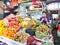 A trader checks her mobiole phone with fruit and vegetables for sale at a market stall in Phnom Penh, Cambodia