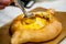 Traditional Adjara khachapuri. In a boat of dough baked cheese,