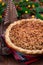 Traditional American apple cranberry pie, topped with crumbled dough and pecan, vertical, bokeh lights