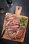 Traditional American barbecue dry aged bavette steak sliced on an old rustic cutting board