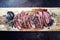 Traditional American barbecue dry aged flank steak sliced on a wooden board