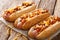 Traditional American chili hot dogs with cheddar cheese, onion a
